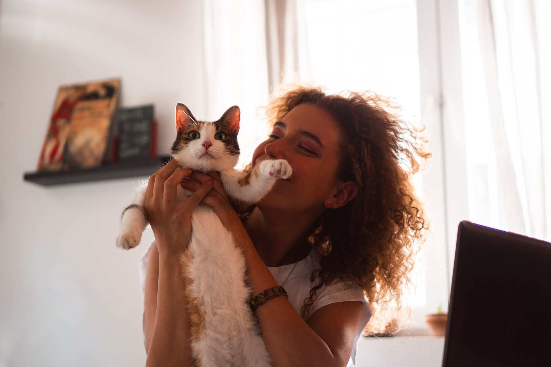 Woman smiling playing and holding cat