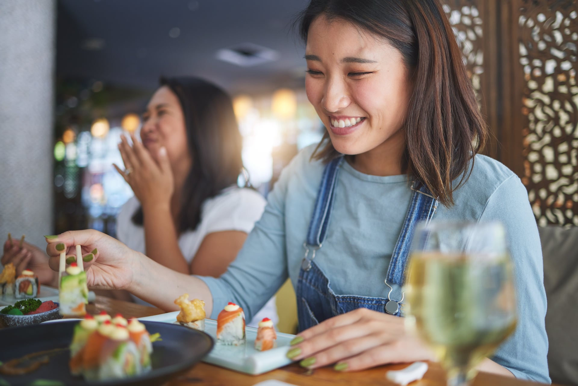Young woman smiling and eating sushi